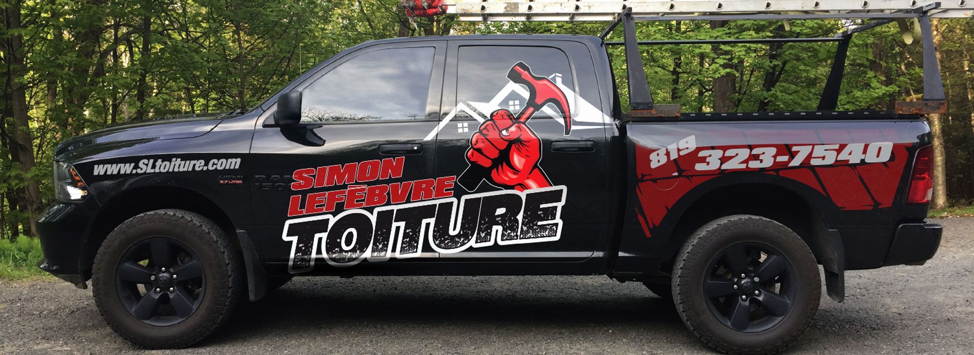 Un camion noir avec le mot toiture sur le côté