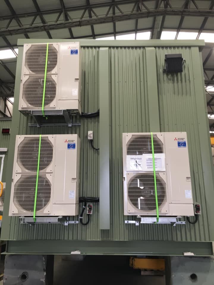 Three air conditioners are stacked on top of each other on the side of a building — Air Conditioning Lake Macquarie