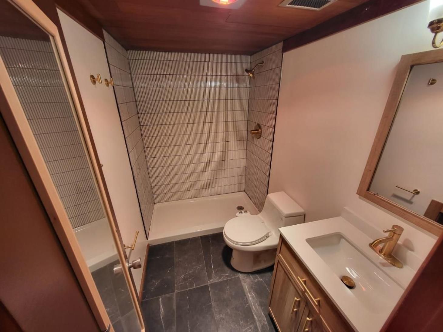 A bathroom with a toilet , sink and shower