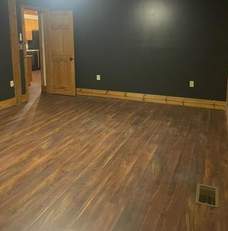 a man is measuring a wooden floor with a tape measure .