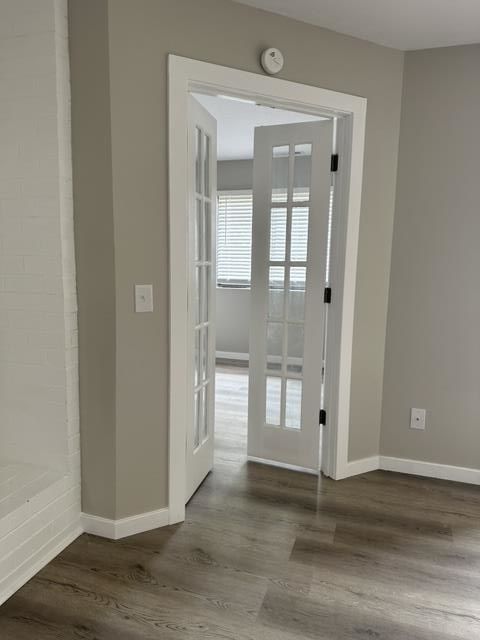 An empty room with a french door leading to a living room.