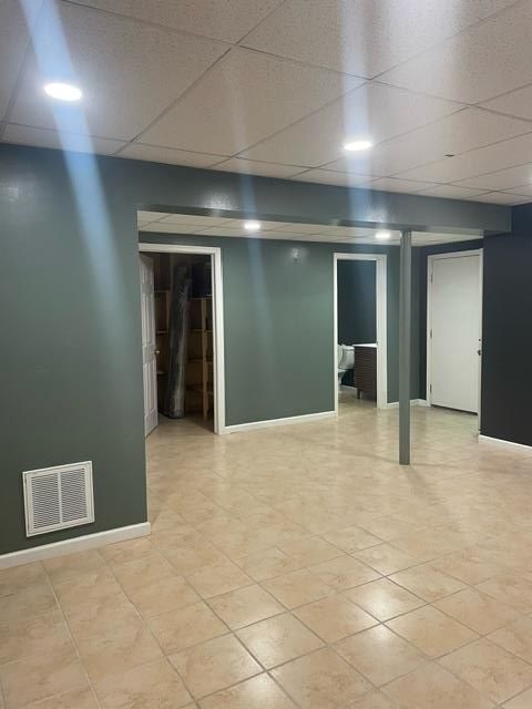 An empty basement with tile floors and green walls