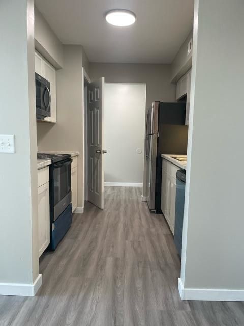 A kitchen with a stove , refrigerator , dishwasher and microwave.