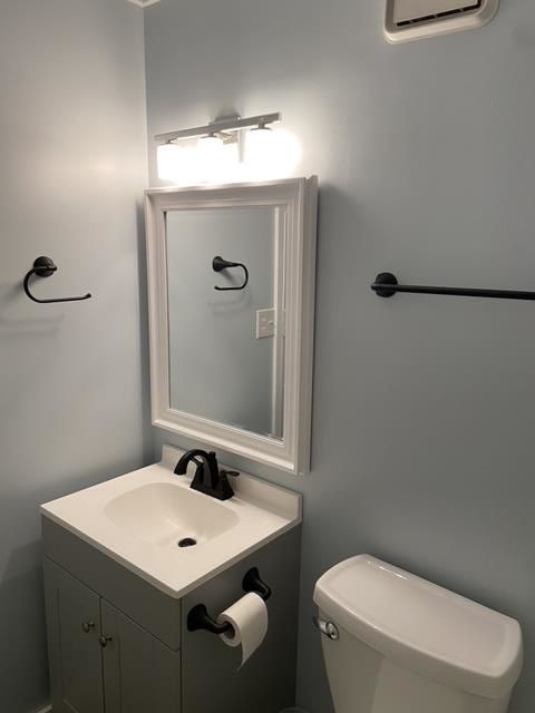 A bathroom with a sink toilet and mirror