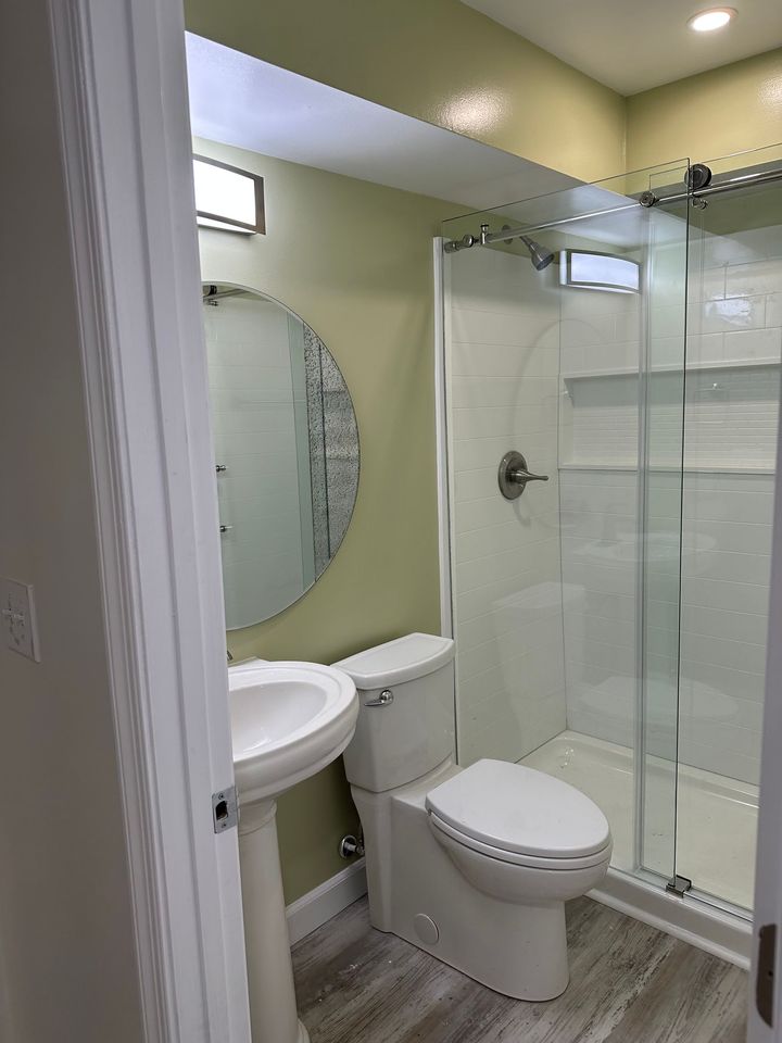 A bathroom with a toilet , sink and shower