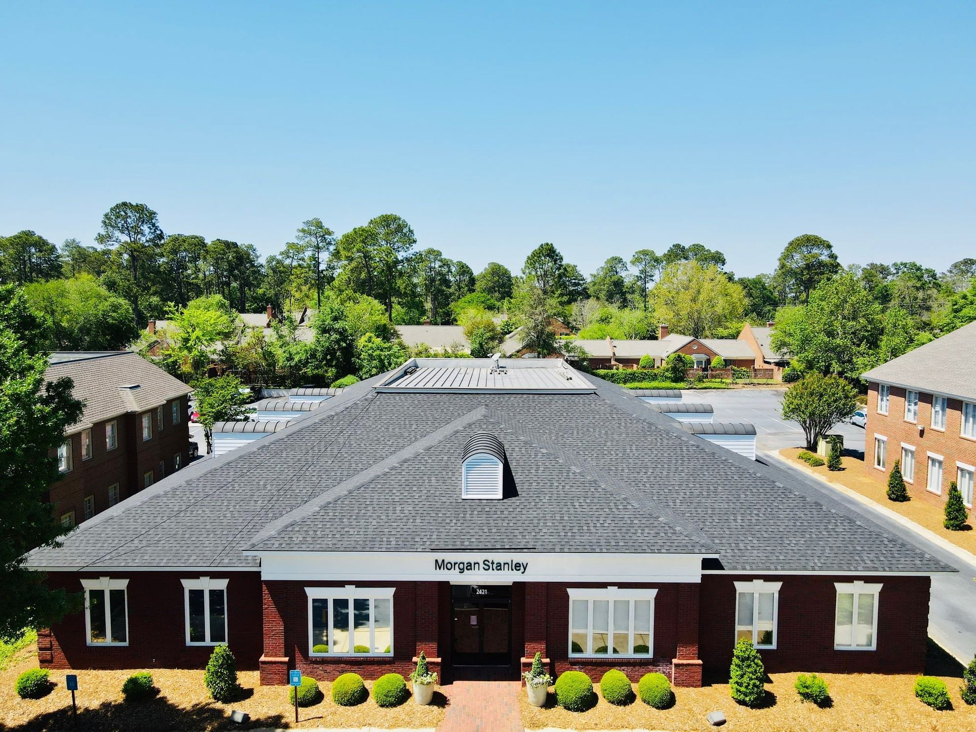 Red brick building with black roof; 