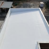 White flat roof with metal edging, viewed from above.