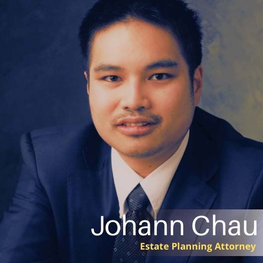 Johann Chau, Asian man, estate planning attorney, in a dark blue suit, looking at the viewer.