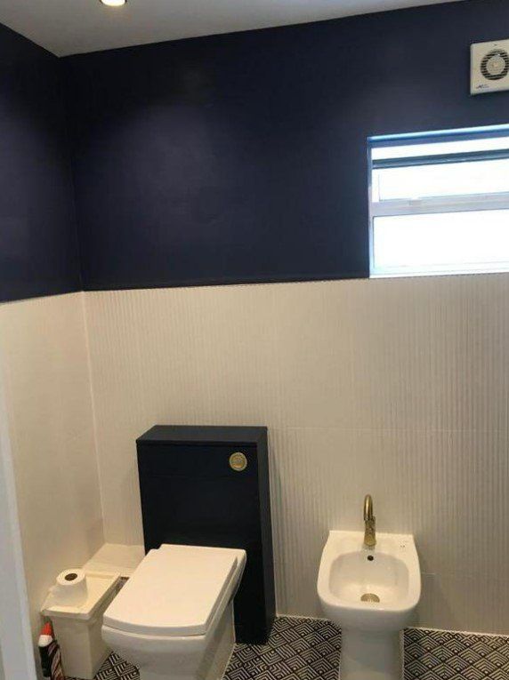 Picture of a bathroom painted in dark blue and white by painters and decorators Liverpool