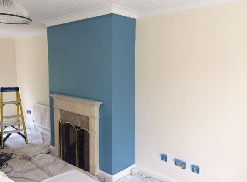 Picture of a living room chimney breast painted in pale blue with magnolia surrounds by painters and decorators Liverpool