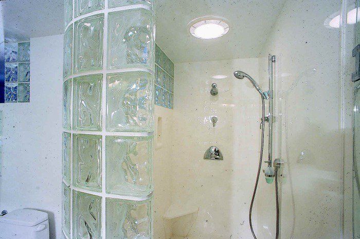 A bathroom with a walk in shower and a toilet.