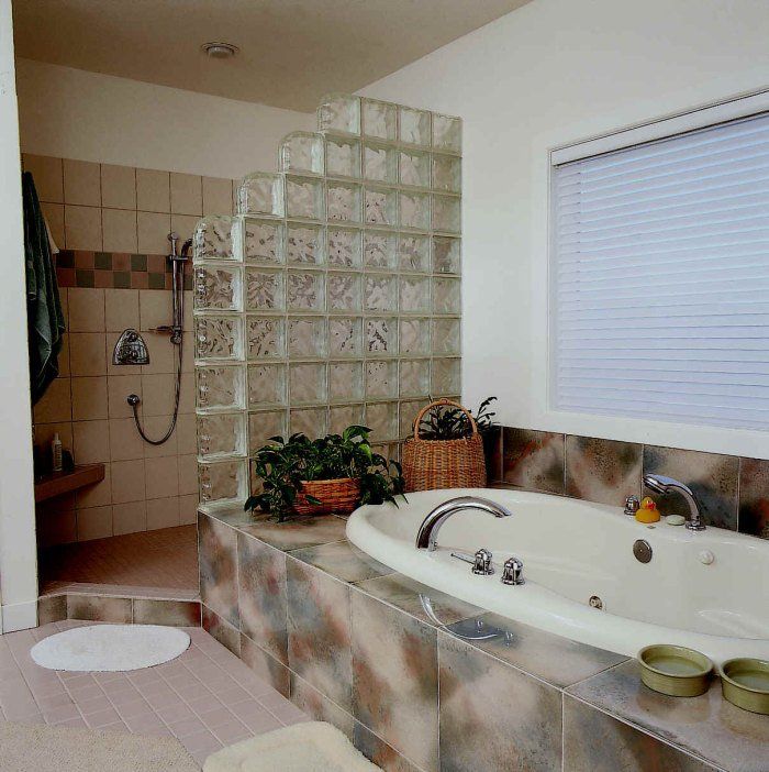 A bathroom with a tub and a window with blinds