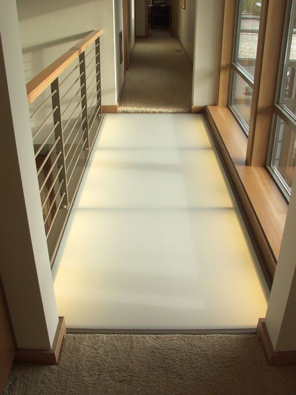 A hallway with a railing and a white floor