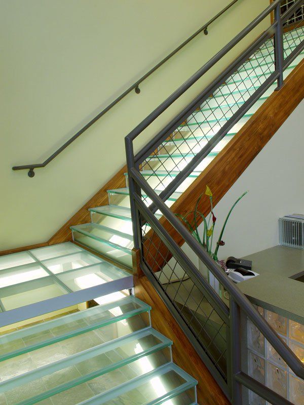A staircase with glass steps and a metal railing
