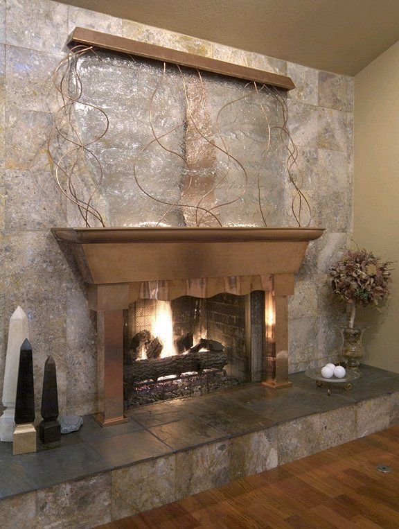A living room with a fireplace and a waterfall on the wall.