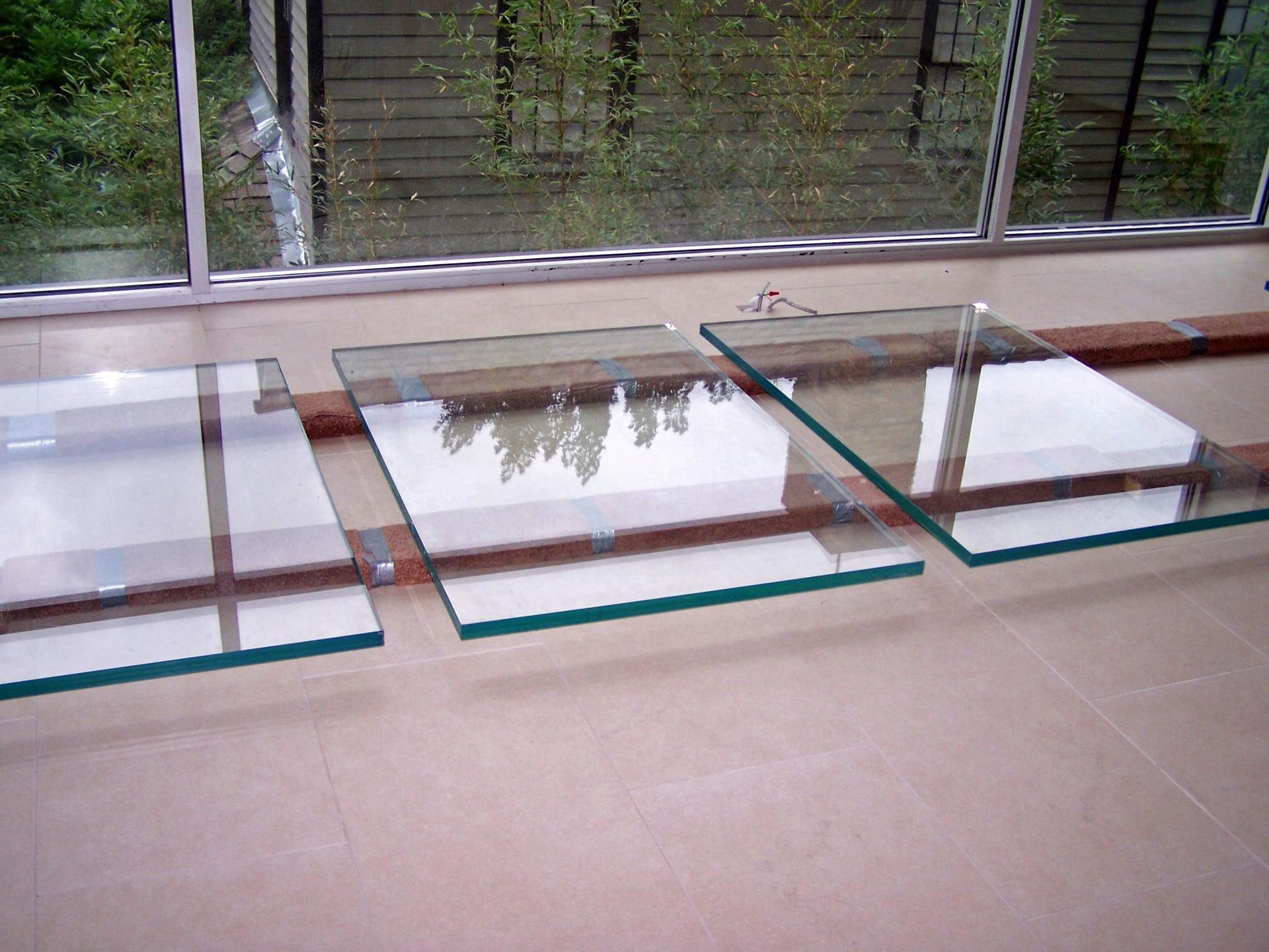 A glass table is sitting in front of a window