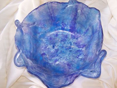 A blue and purple bowl is sitting on a white cloth