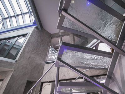 Looking up at a spiral staircase with glass steps
