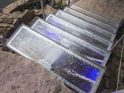 A set of stairs made of glass and stainless steel.