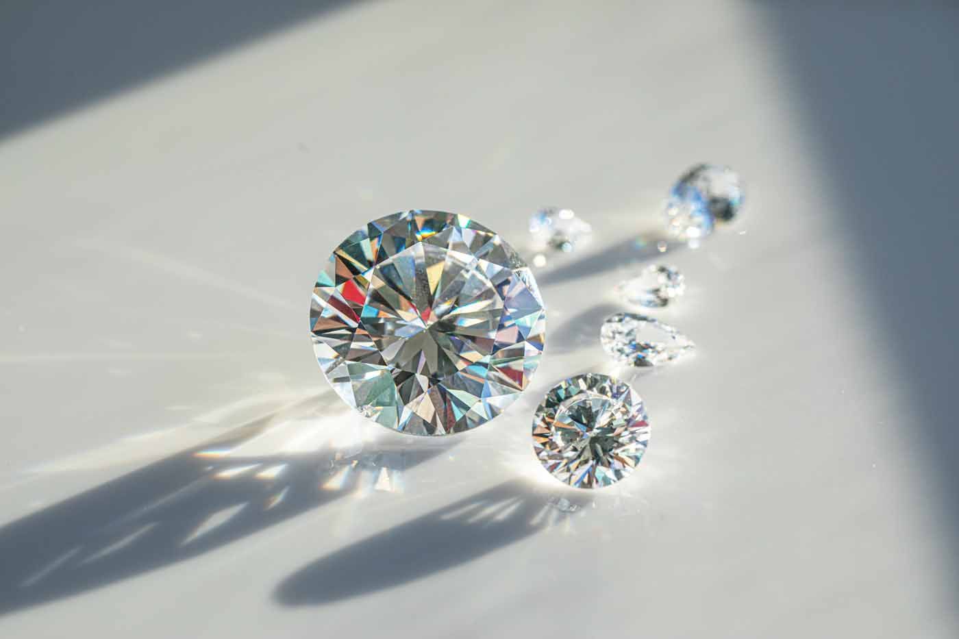 A group of diamonds are sitting on a white surface.