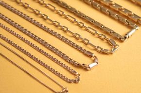 A bunch of different types of chains are lined up on a table
