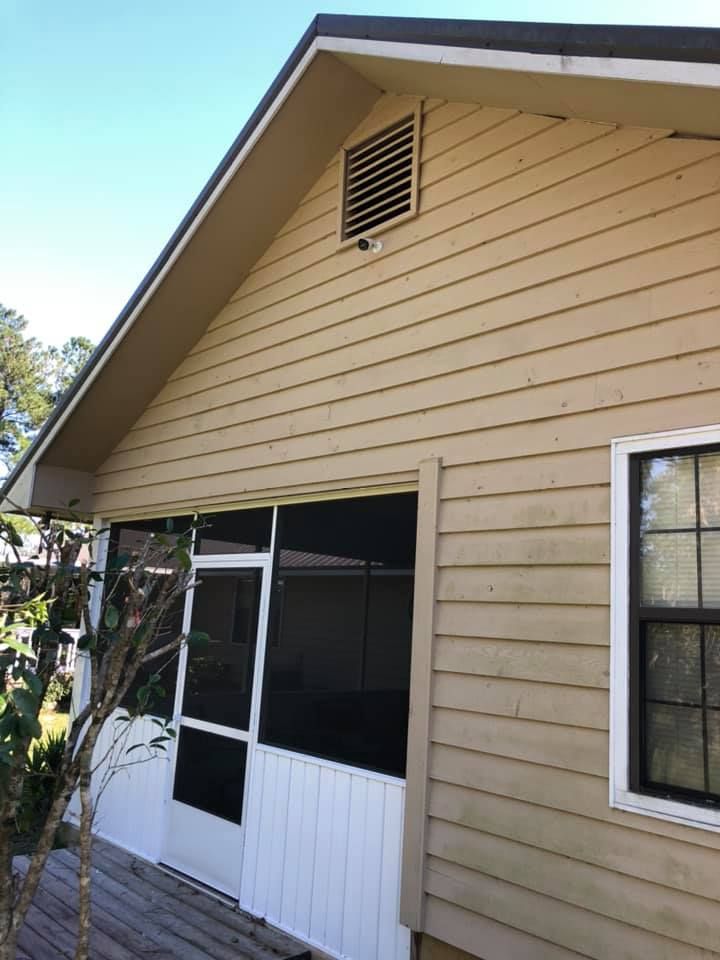 Tan siding on a house with a screened porch and a window. Vents are visible under the roofline.