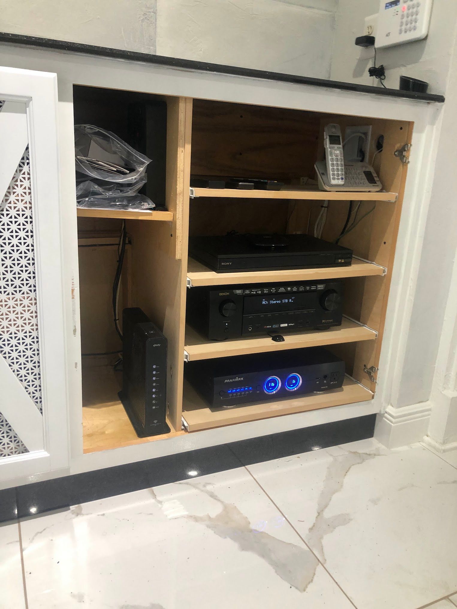 White and black cabinet with audio/video equipment inside.