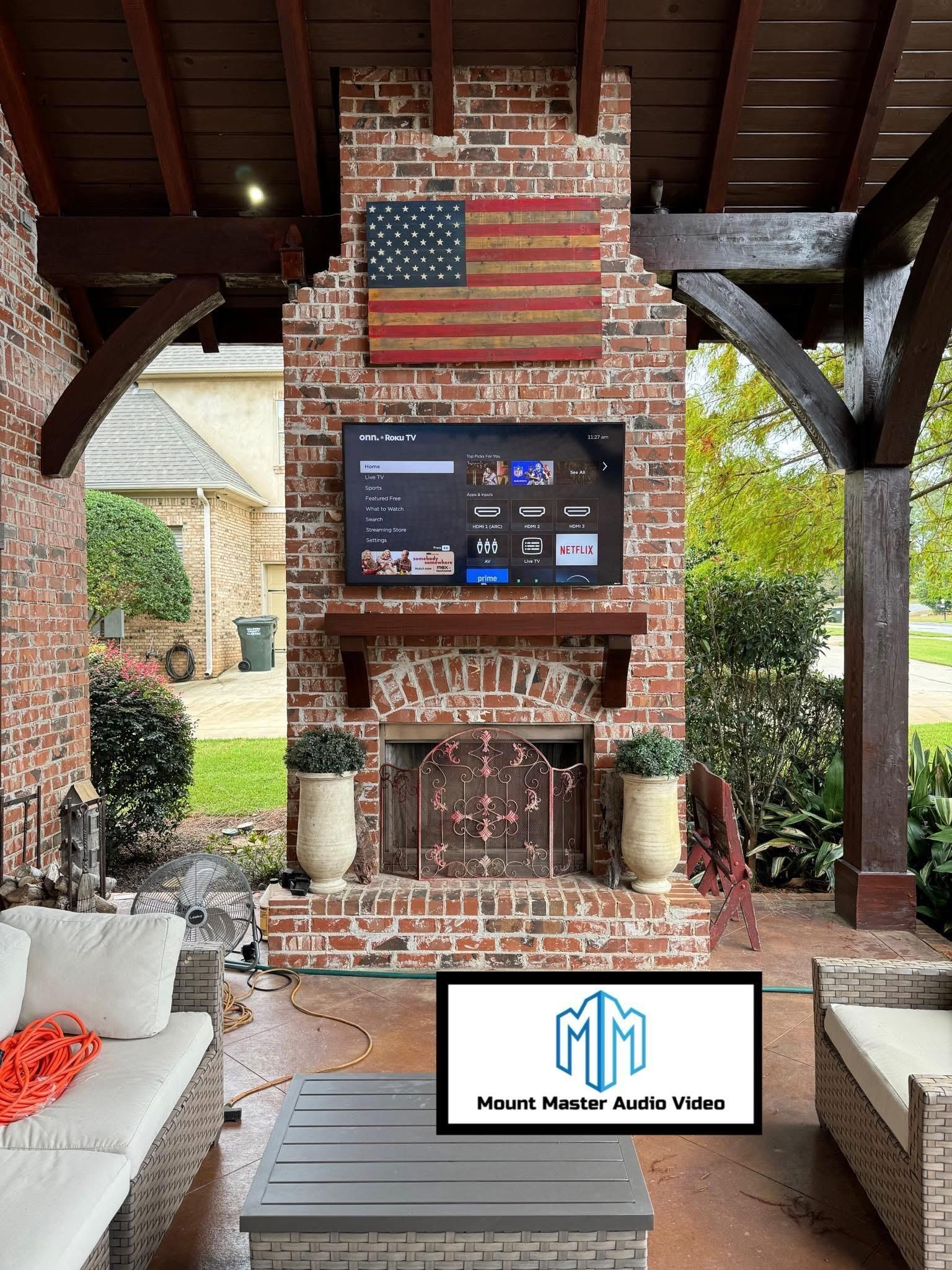 Brick fireplace with TV, American flag, and patio furniture.