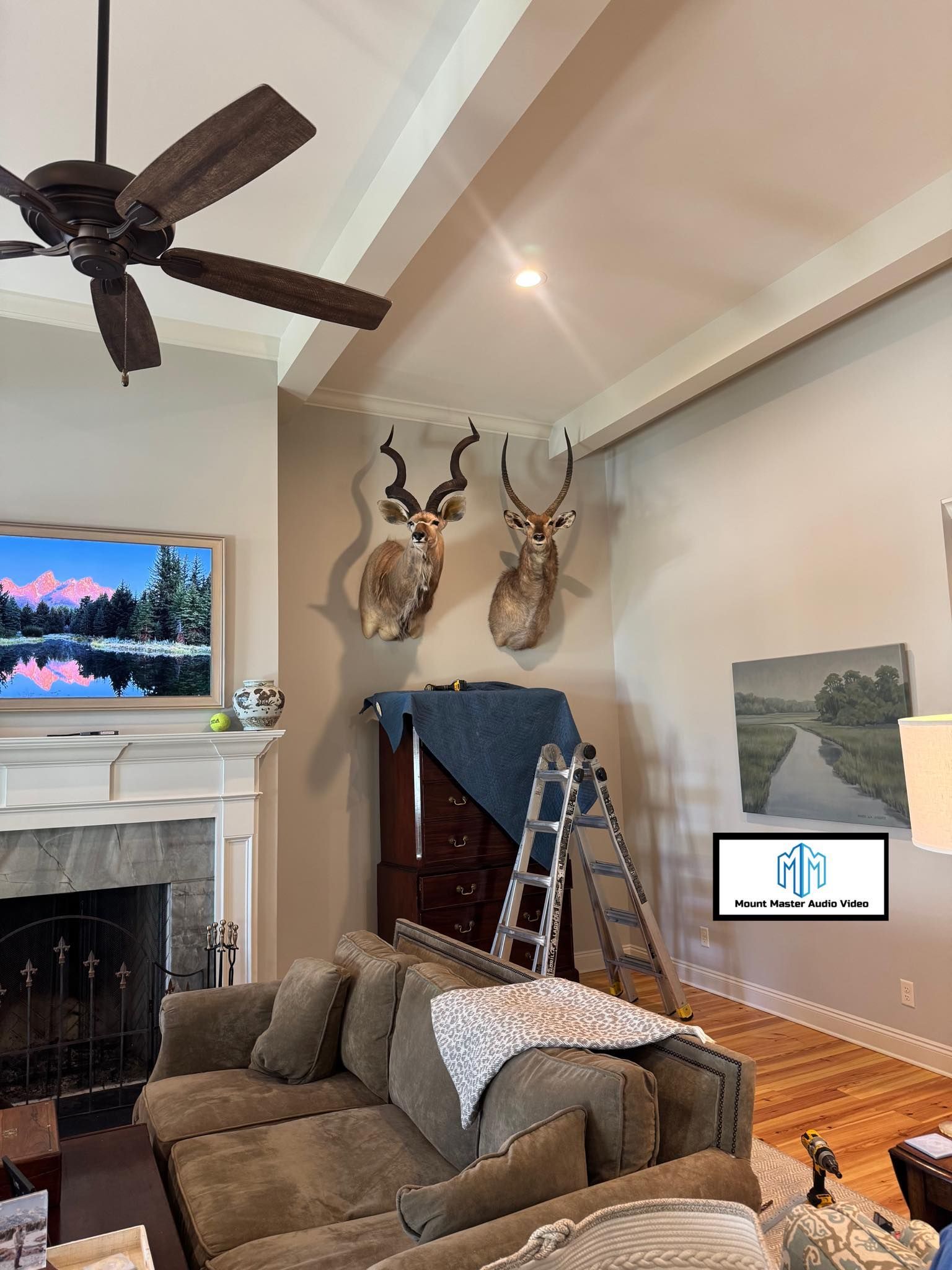 Living room with mounted animal heads, a couch, and a fireplace.