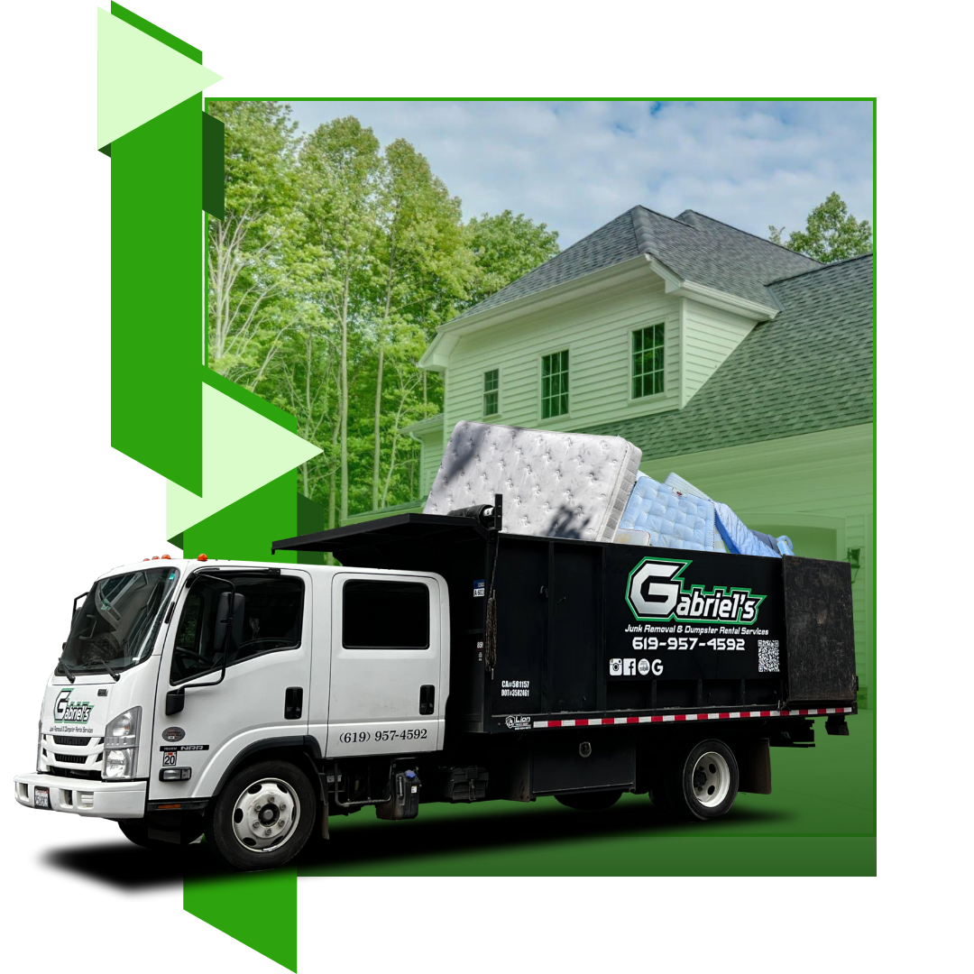 A garbage truck is loaded with discarded mattresses in front of a house.