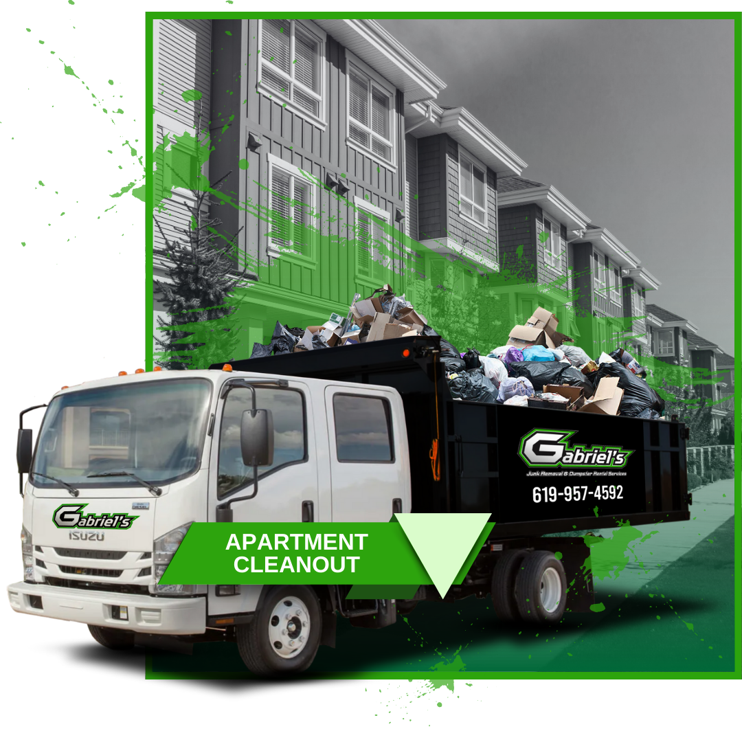 A garbage truck is full of garbage in front of a building.