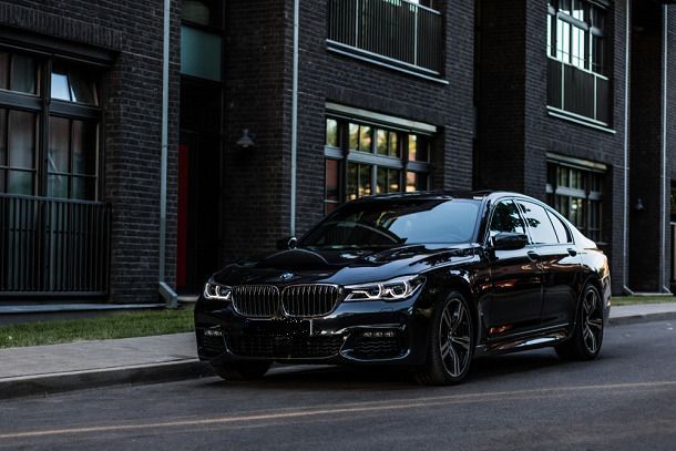 A black mercedes benz sprinter van is parked on a tiled floor.