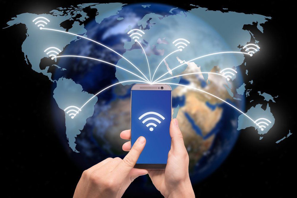Hand Holding Smart Phone on World Map With Wireless Communication Network — Superior Wifi In East Ballina, NSW