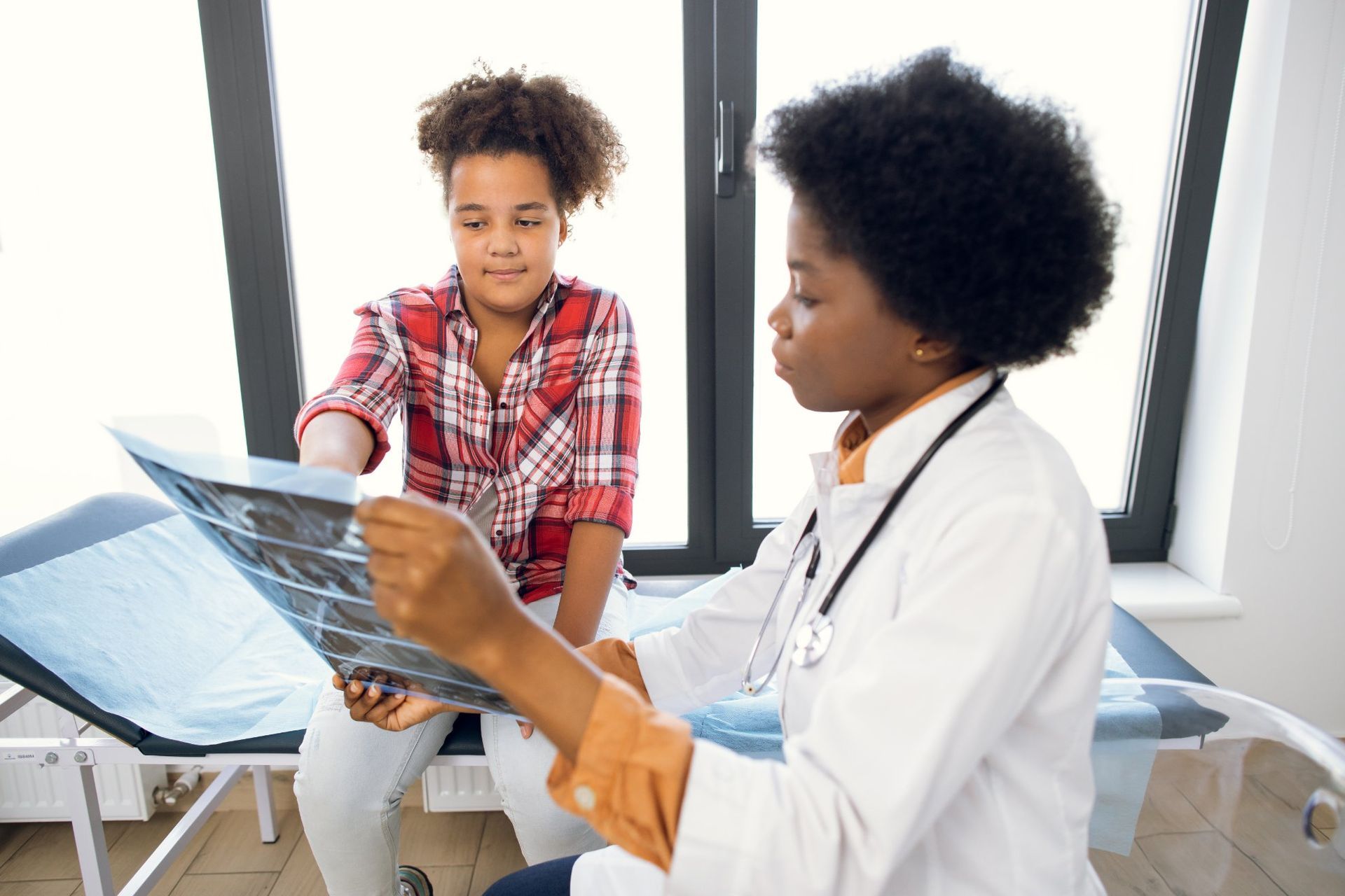 A doctor is looking at an x-ray with a patient.