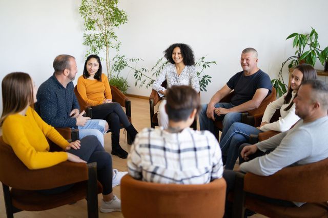 A group of people are sitting in chairs in a circle.