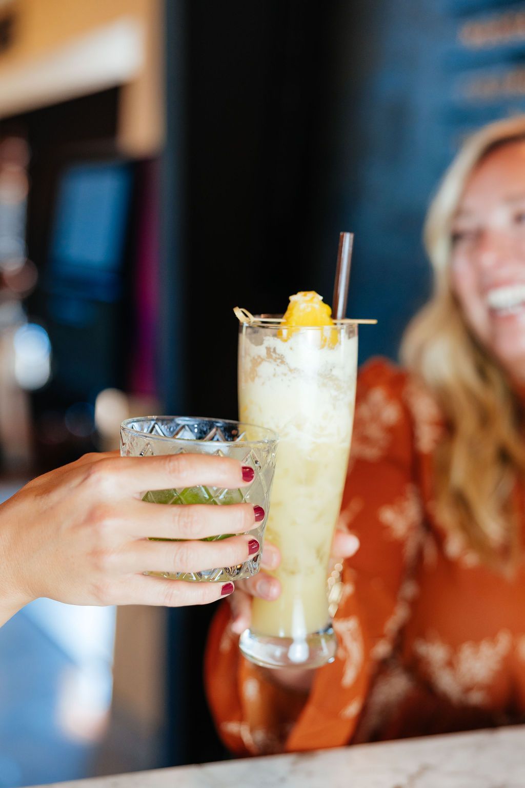 Two People Clinking Their Cocktail Drinks From Six Mile Ordinary in Columbia, MO.