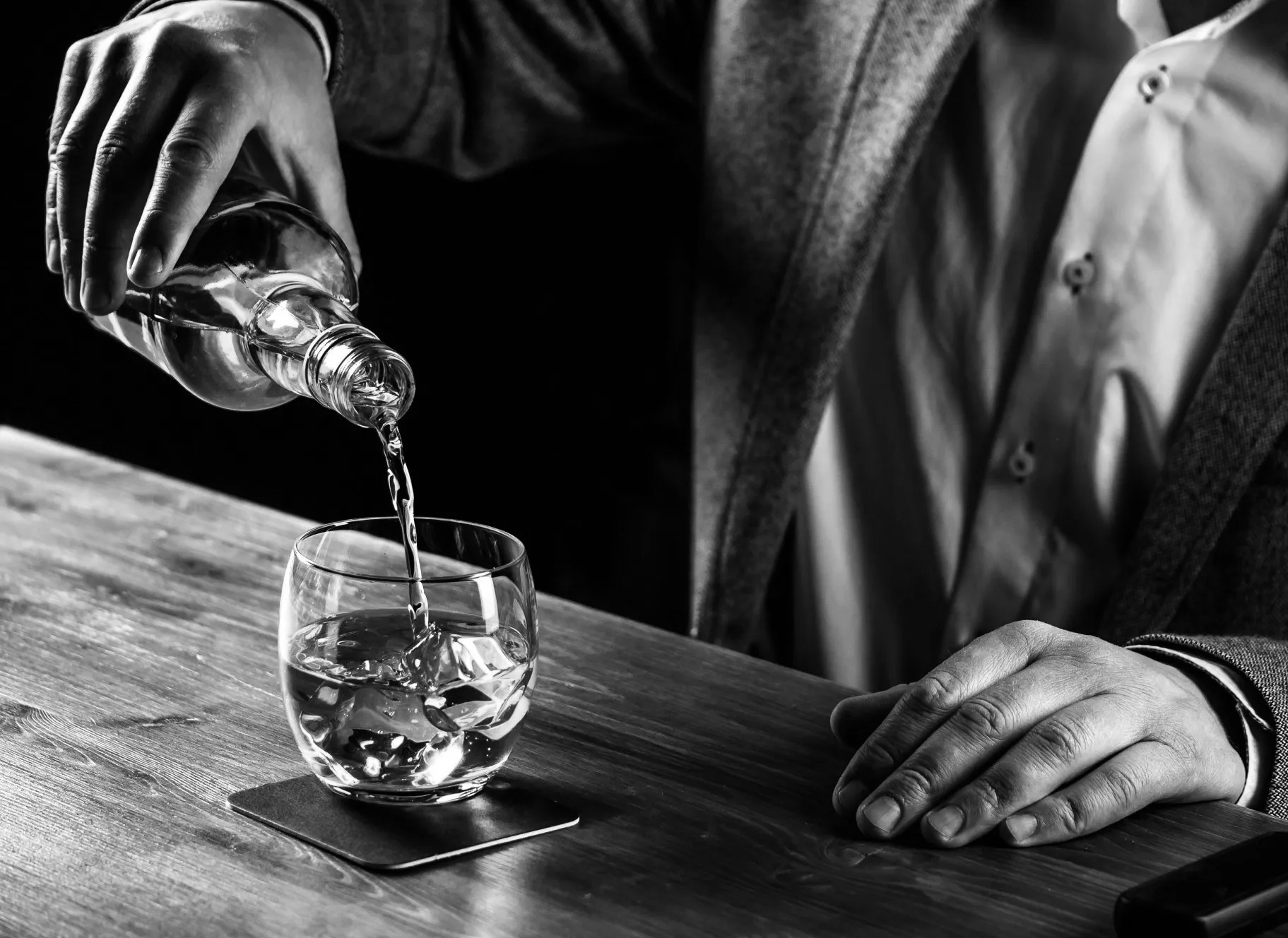Man Pouring Whiskey Into a Glass. Visit Six Mile Ordinary in Columbia, MO for Quality Spirits.