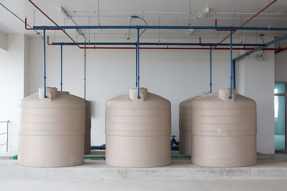 Three Residential Water Tanks Are Lined Up In A Room — LTR Water Deliveries In Wamuran, QLD