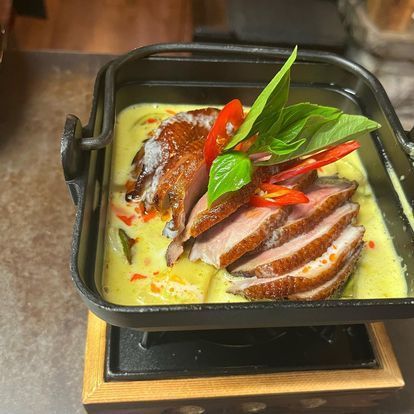 Une poêle remplie de viande tranchée et de légumes sur une table.