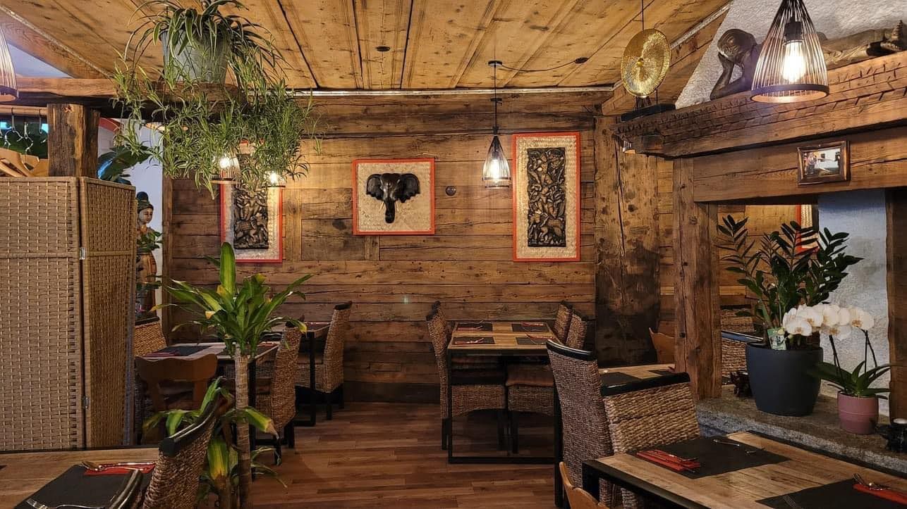 Un restaurant avec des tables et des chaises en bois et une cheminée.