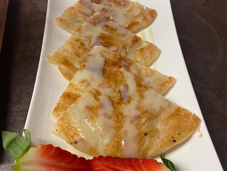 Une assiette blanche garnie de nourriture et de fraises sur une table.