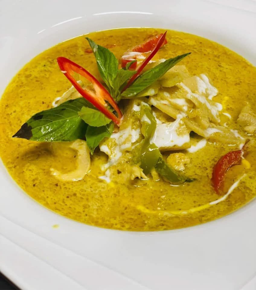 Un gros plan d'un bol de soupe avec des légumes sur une assiette blanche.