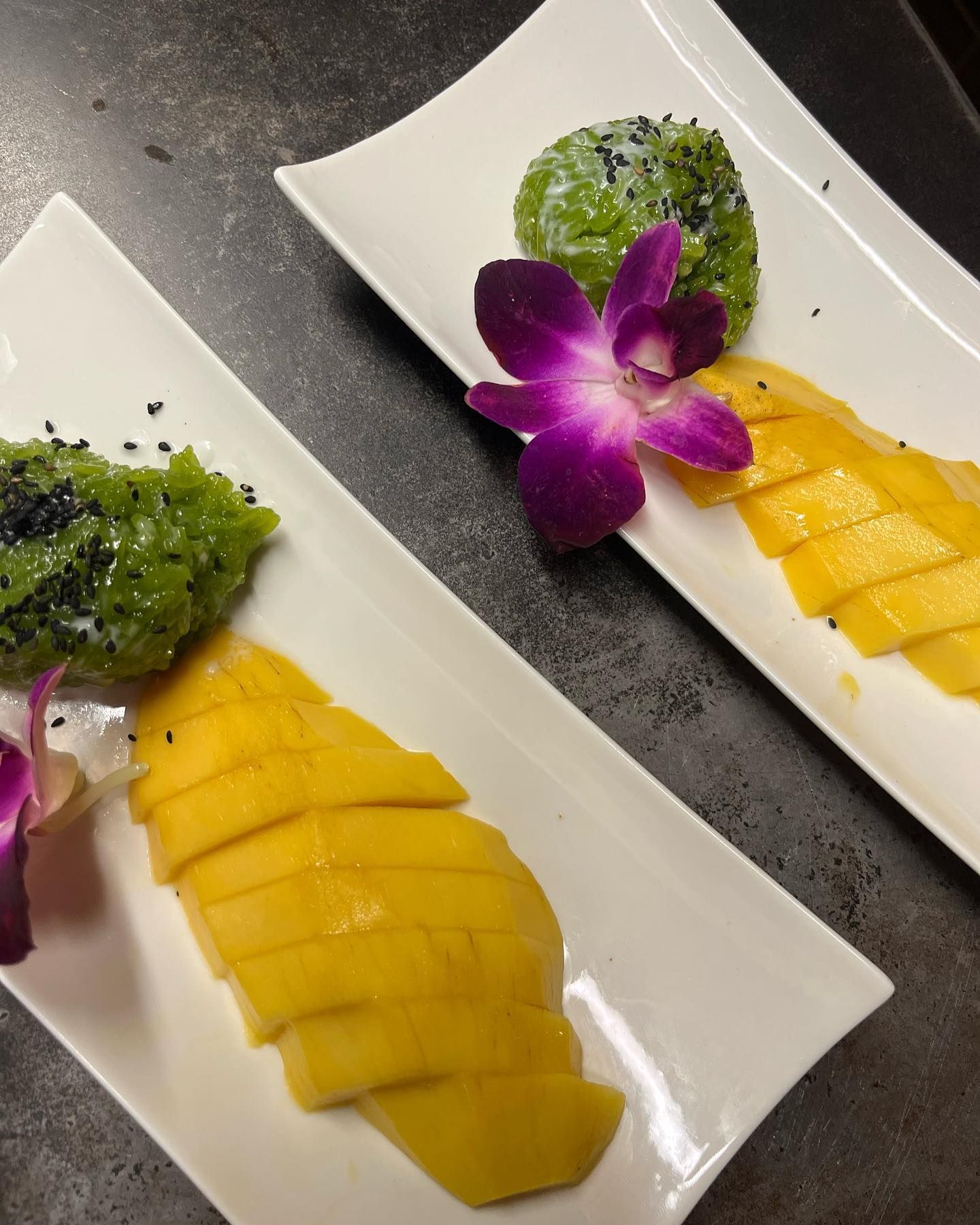 Deux assiettes blanches avec des tranches de fruits et des fleurs dessus