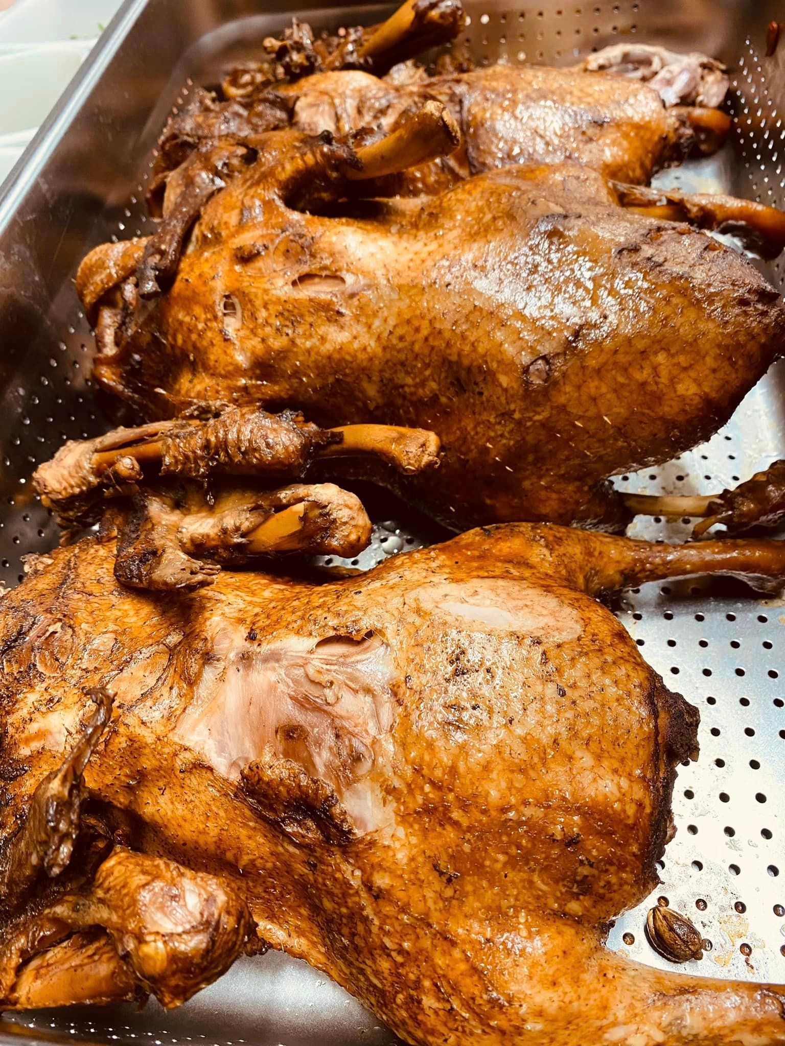 Deux poulets rôtis sont posés l'un sur l'autre dans une poêle.