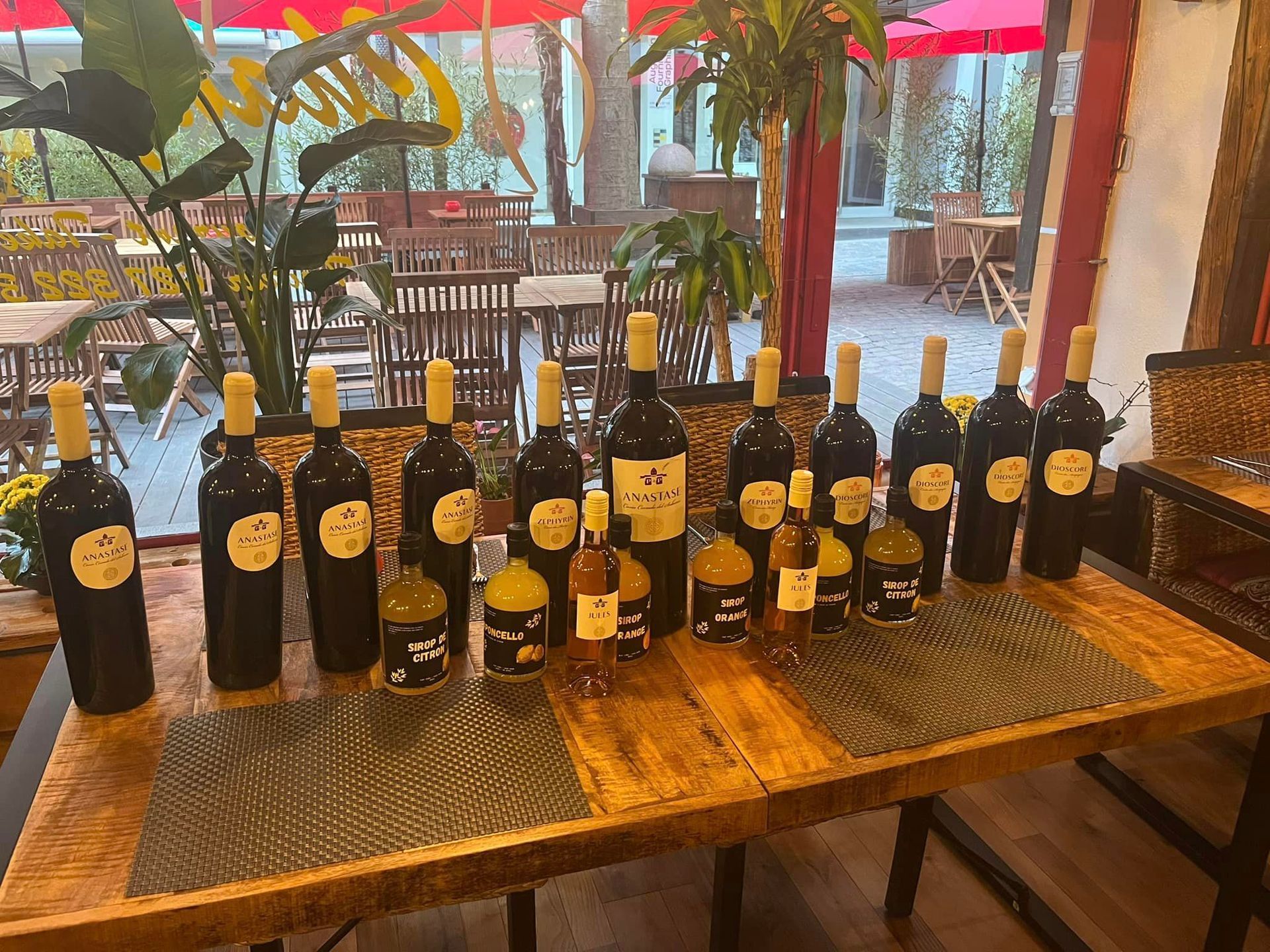 Une rangée de bouteilles de vin est posée sur une table en bois.