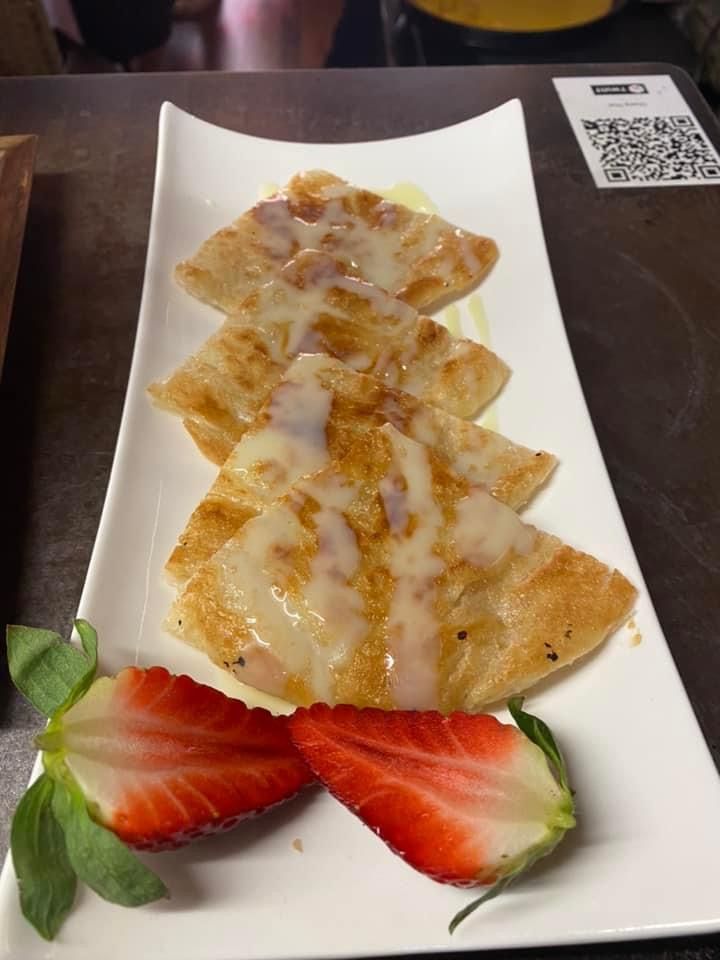 Une assiette blanche garnie de nourriture et de fraises sur une table.