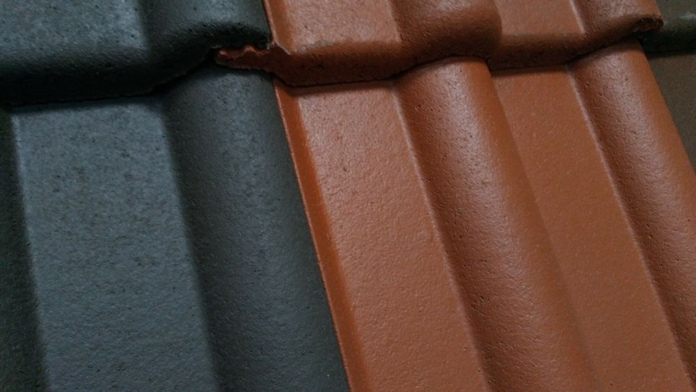Close-up of overlapping terracotta and black roof tiles — Geoff Hall Roofing in Port Macquarie, NSW