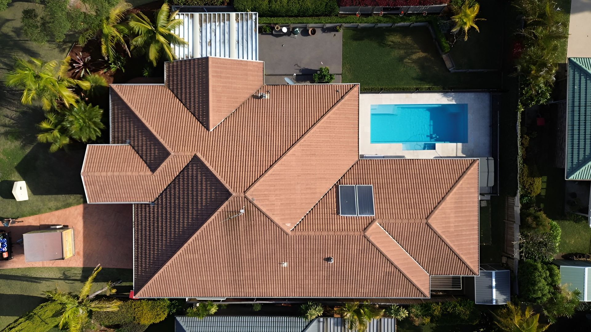 Overhead View of A House with A Brown Roof, Pool, and Lush Green Lawn — Geoff Hall Roofing in Kempsey, NSW