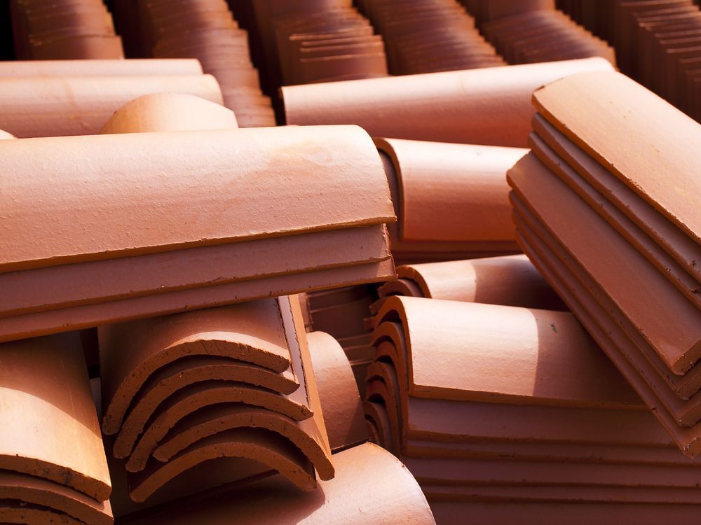 Stacks of terracotta roof tiles, outdoors — Geoff Hall Roofing in Harrington, NSW