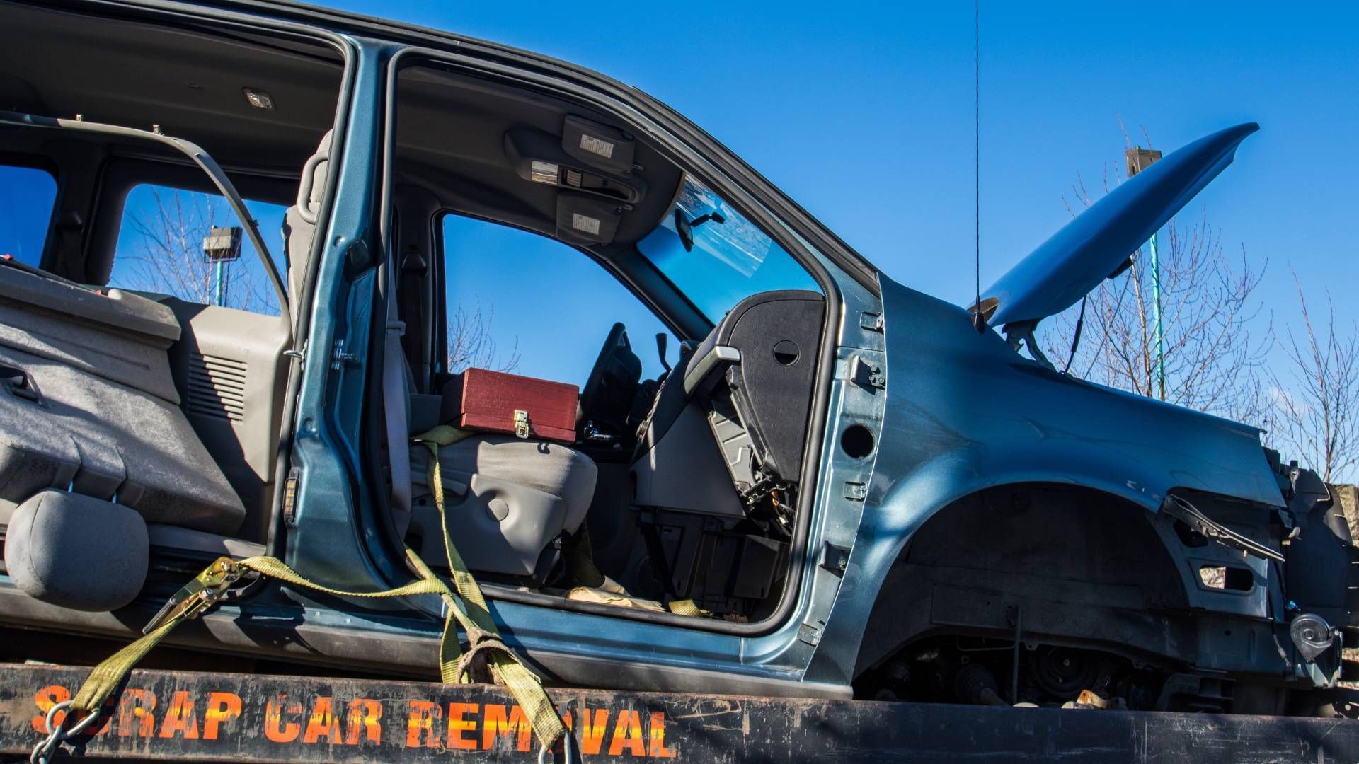 A wrecked car is sitting on top of a tow truck.